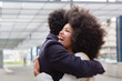 © Emma Innocenti/Westend61 - Laughing Afro woman embracing boyfriend at railroad station