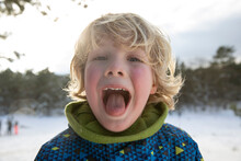 Blond Hair Boy Sticking Out Tongue During Winter