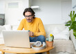 © Jose Carlos Ichiro/Westend61 - Man with eyeglasses looking at laptop while sitting on sofa in living room