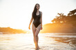 © Ian Spanier/Westend61 - Seductive female walking wearing swimsuit at beach