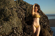 © Ian Spanier/Westend61 - Happy mid adult model in bikini in front of clams rock at beach