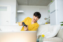Excited Woman Playing Game With Joystick At Home