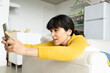 © Jose Carlos Ichiro/Westend61 - Woman using smart phone at home