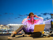 © Jose Carlos Ichiro/Westend61 - Smiling woman enjoying music on headphones while sitting outdoors at night
