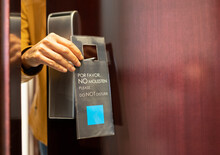 Woman Holding Do Not Disturb Sign Label At Hotel Door