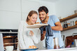 © Joseffson/Westend61 - Man showing freshly baked croissant to girlfriend in kitchen at home
