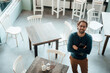 © Joseffson/Westend61 - Confident man with arms crossed standing in coffee shop