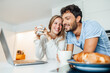 © Joseffson/Westend61 - Happy young couple having coffee while leaning on kitchen counter at home