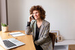 © Sus Pons/Westend61 - Smiling female freelancer talking on smart phone while sitting on chair at home