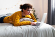 © Sus Pons/Westend61 - Mature woman using laptop while lying on bed at home