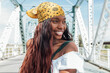 © Julio Rodriguez/Westend61 - Smiling woman with bandana looking away at bridge