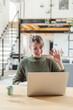© 27exp/Westend61 - Female entrepreneur waving during video call on laptop at home