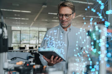 Smiling male engineer with digital tablet working on networking project