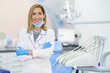 © Javier Sanchez Mingorance/Westend61 - Smiling female dentist with arms crossed standing at medical clinic
