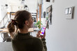 © 27exp/Westend61 - Young woman using smart home function on mobile phone at home