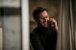 © Malte Jager/Westend61 - Happy man talking on phone at home office