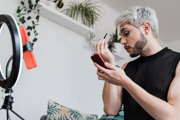 Drag queen doing social media live makeup tutorial - Technology and gender fluid influencer lgbt concept - Focus on face