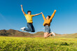 © Miguel Frias/Westend61 - Young couple jumping with joy over grass