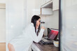 © Manu Reyes/Westend61 - Sensual female professional using laptop in kitchen while working at home