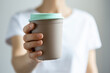 © Julia Otto/Westend61 - Woman holding disposable cup in front of white background