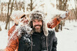 © Malte Jager/Westend61 - Smiling girlfriend throwing snow on man in forest