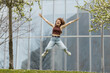© Mikel Taboada/Westend61 - Playful woman with arms outstretched jumping over grass