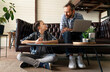 © OneInchPunch/Westend61 - Father with laptop discussing with son while sitting at home