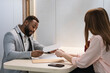 © NOVELLIMAGE/Westend61 - Businessman discussing over paper with colleague at office