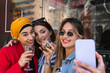 © NOVELLIMAGE/Westend61 - Beautiful woman taking selfie through smart phone with female friends while having drinks