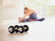 © Phillip Waterman/Westend61 - Dumbbells on floor while woman exercising at home