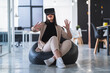 © SERGIO NIEVAS/Westend61 - Female professional gesturing while enjoying virtual reality on bean bag in coworking office