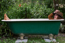 Clothed Man Relaxing In Outdoor Bathtub