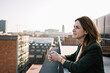 © Xavier Lorenzo/Westend61 - Thoughtful woman standing near railing at building terrace