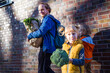 © Irina He√ü/Westend61 - Girl carrying broccoli while father with vegetable bag standing against son