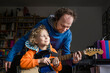 © Irina He√ü/Westend61 - Man teaching guitar to smiling son looking away at home