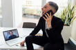 © Eugenio Marongiu/Westend61 - Happy businesswoman talking on mobile phone during video call through laptop at office