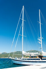 Wall Mural - Stunning view of a sailboat moored to a port during a sunny day. Porto Rotondo, Sardinia, Italy.