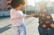 © Eugenio Marongiu/Westend61 - Young women playing while holding hands on footpath