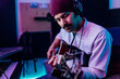 © Eugenio Marongiu/Westend61 - Male guitarist wearing knit hat playing guitar at home studio