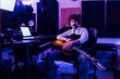 © Eugenio Marongiu/Westend61 - Male guitarist with guitar sitting at home recording studio