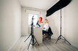 © Manu Reyes/Westend61 - Female make-up artist applying face powder on model while blogging at studio