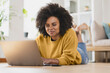 © steve brookland/Westend61 - Smiling woman using laptop while lying down at home