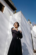 © Tania Cervian/Westend61 - Beautiful woman standing with arms crossed in front of white building