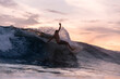 © Konstantin Trubavin/Westend61 - Tourist surfing over waves in sea during sunset
