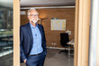 © Uwe Umstatter/Westend61 - Mature businessman looking away while leaning on doorframe at office