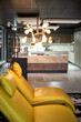 © victor espadas/Westend61 - View to modern open plan kitchen with yellow leather chairs in the foreground