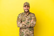© luismolinero - Military man isolated on yellow background keeping the arms crossed in frontal position