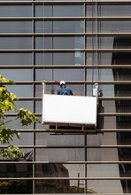 Faceless Male Window Washer Cleaning High Building Facade In Construction