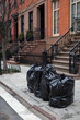 Black Trash Bags on a Curb along a Street in Greenwich Village of New York City