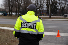 Rear View Of A Security Guard Watching Over The Parking Area